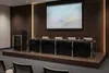Стол президиума Техно с тёмным фасадом и нержавеющей опорой в конференц-зале.
