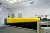 Стойка ресепшн РИ-214 из черной ЛДСП с желтой накладкой из искусственного камня в офисном интерьере.