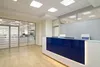 Стойка ресепшн Казимир с синим фасадом в офисе со стеклянными перегородками и LED-подсветкой.