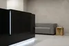 Крупный план торца ресепшн Казимир чёрный: вертикальная LED-вставка и нижняя подсветка цоколя.