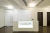 Стойка ресепшн Хибины белая с брендингом, угловой вид, стеклянная столешница.