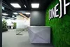 Стойка ресепшн Кристалл из микроцемента на фоне open-space офиса ONE.