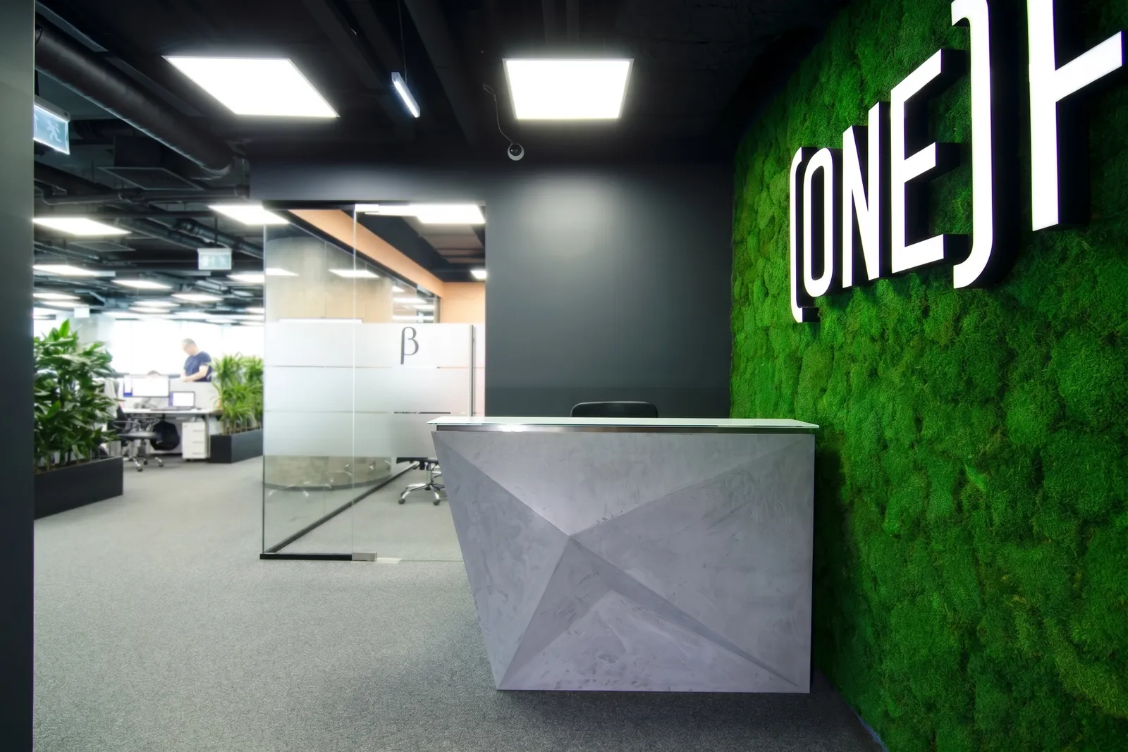 Стойка ресепшн Кристалл из микроцемента на фоне open-space офиса ONE.